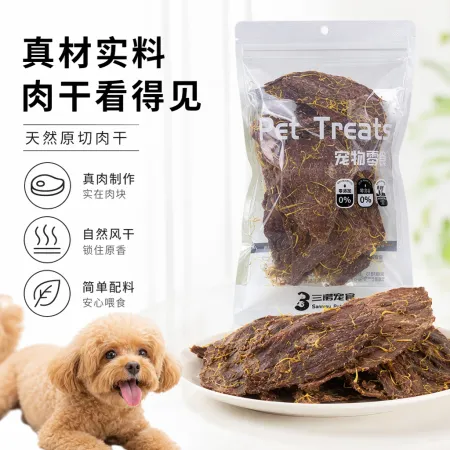 Holding a transparent bag of pet snacks, dark brown dried meat with yellow crumbs, green grass and a blue sky background Holding a transparent bag of pet snacks, dark brown dried meat with yellow crumbs, green grass and a blue sky background